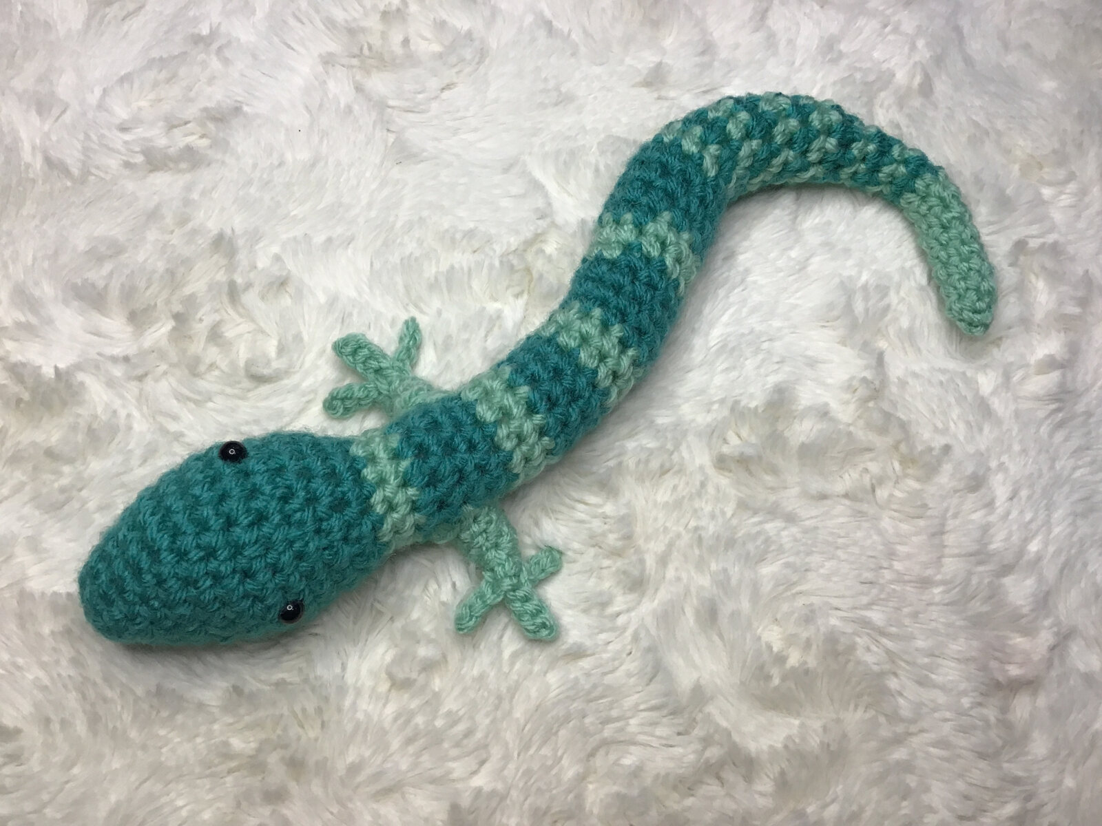 Long teal crocheted lizard with curled tail