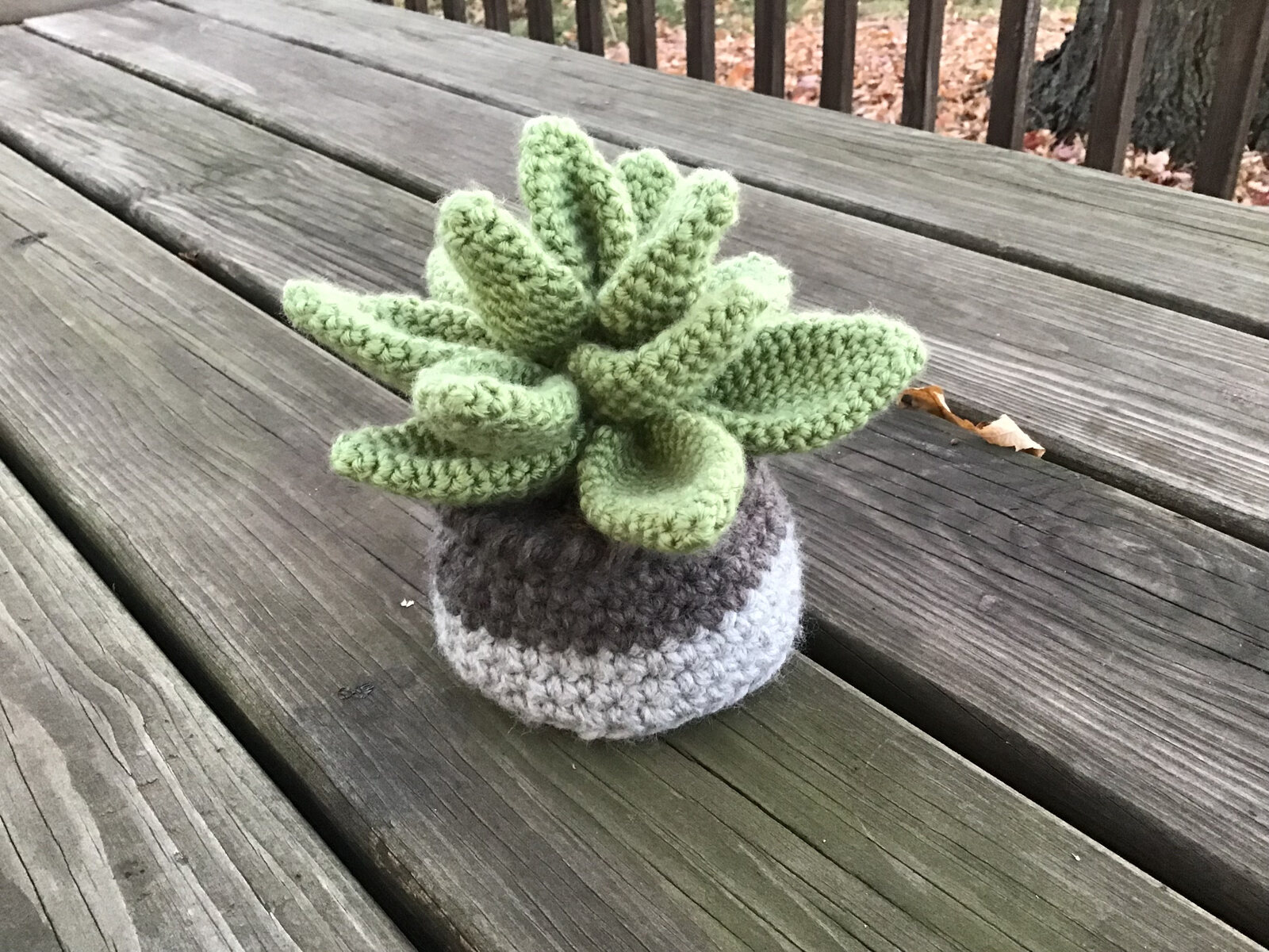 Crocheted green succulent in a small gray and white pot
