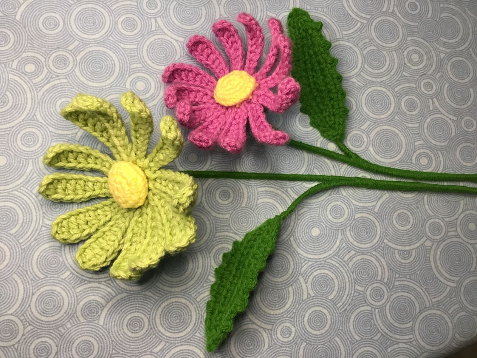 Two long-stemmed crocheted flowers